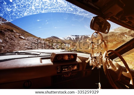 Off road car climbs to mountain pass. View from inside the car