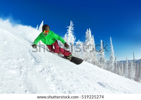 Active man snowboarder riding on slope. Snowboarding closeup. Sheregesh ski resort