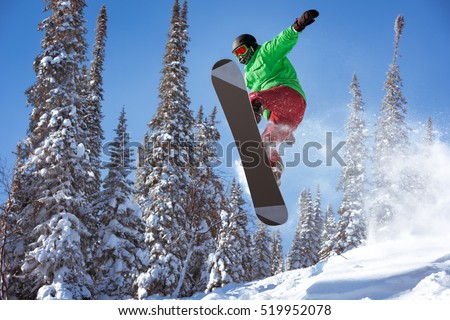 Snowboarder jumps in forest. Freeride snowboarding in Sheregesh ski resort