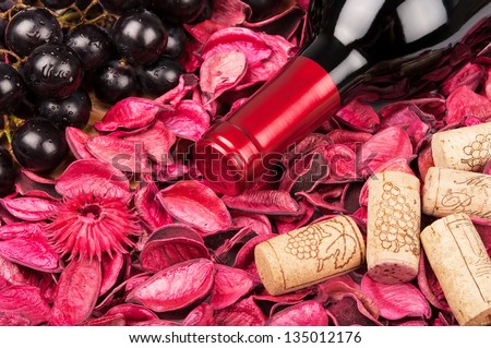 Bottle of red wine on flower petals background