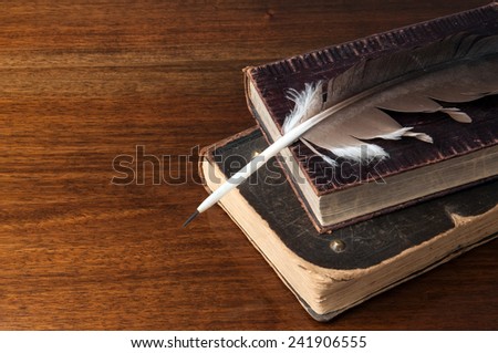 Old books and a fountain pen on wooden table background