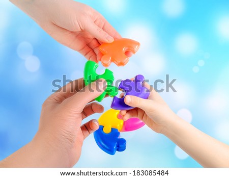 father\'s hands to help his son to collect puzzle