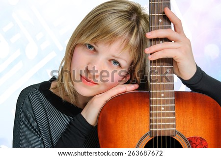 Woman holding a guitar and running his fingers through the strings. Isolated on white background