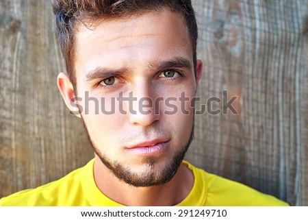 handsome man looking in one direction on a gray wooden background
