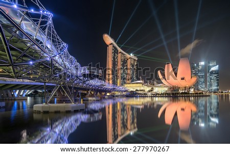 SINGAPORE - NOVEMBER 09, 2014: The Helix Bridge, Marina bay sands at night. Marina Bay Sand iconic design has transformed Singapore\'s skyline. Designed by architect Moshe Safdie.