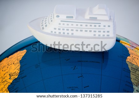 A model ship on a world map. Studio shot with white background