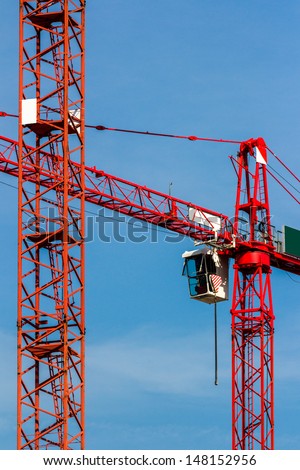 Detail of red cranes on a blue summer sky