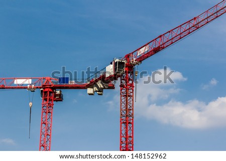Detail of red cranes on a blue summer sky