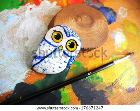 Painted stone owl on a palette