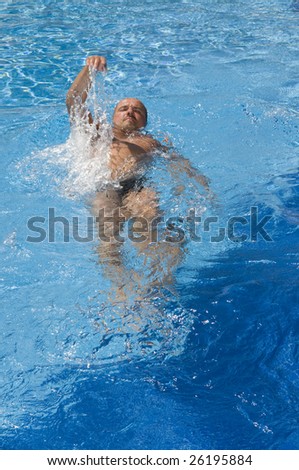 Swimming man in a pool with light-blue clear water
