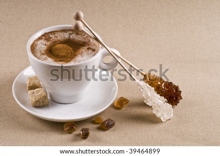 Cappuccino coffee cup with brown caramel  sugar over textured background