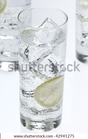 Glasses objects with soda water , ice cubes and lemon