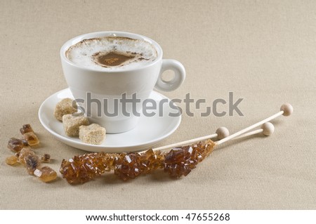 Cappuccino coffee cup with brown caramel  sugar over textured background