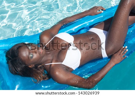 African American young woman relaxing in swimming pool