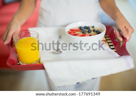 Woman holding tray with breakfast