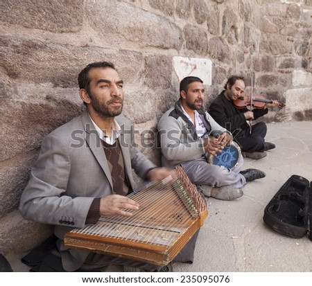 ANKARA, TURKEY - MARCH 30, 2013: Street musicians.Three gypsy musicians playing famous Turkish songs while the visitors enjoying the view and music inside Ankara Castle in Ulus, Ankara.