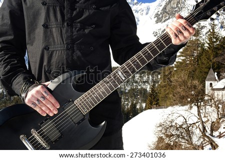Band member with love tattoos holding a guitar