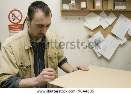 Young joiner making furniture in his manufactory