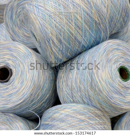 pile of spools of multi coloured yarn in pastel shades
