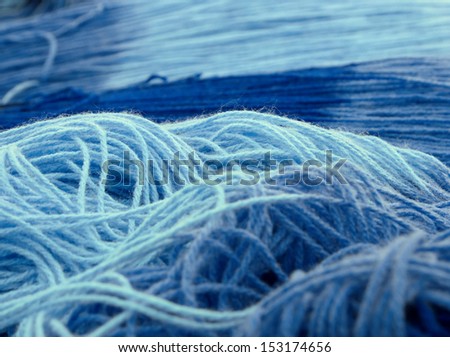 close up tangled skeins of wool in different blue shades with selective focus