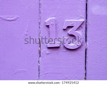 purple painted door with the number thirteen on it