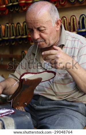 old man making handmade slippers for ladies