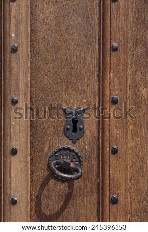 Old oak door with iron ring latch handle and ornate key hole