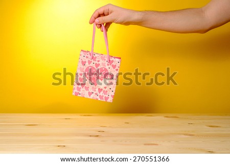 Man holding present in pink shopping bag