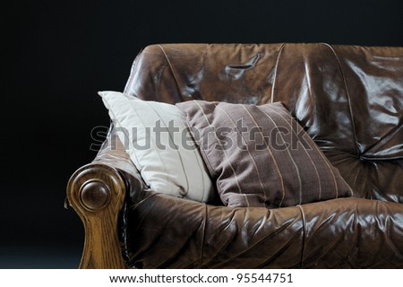 The image shows a leather couch with two beddings