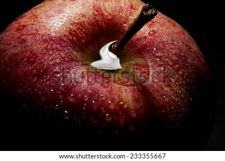 The image shows a part of an apple with water drops