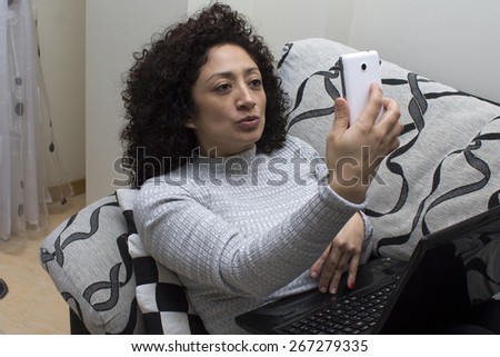 woman on the sofa with computer and mobil