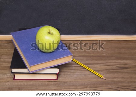 blackboard, books and apple on desk