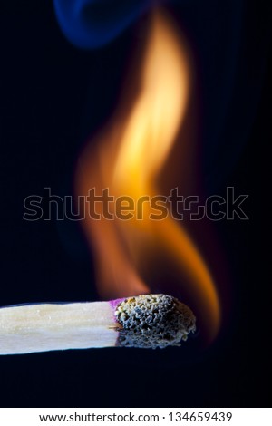 Burning Match stick over black background