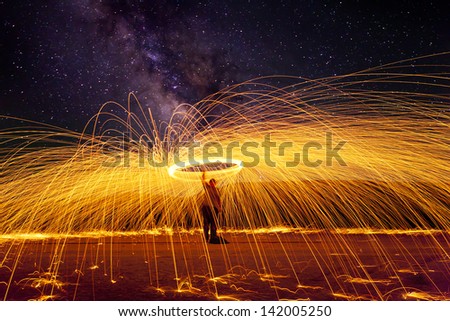 shower of glowing hot sparks with milky way background at night
