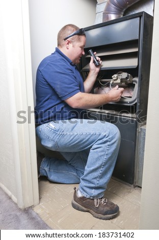 Heater repair technician working on furnace