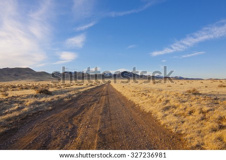 Desert Dirt road with beautiful blue sky.
