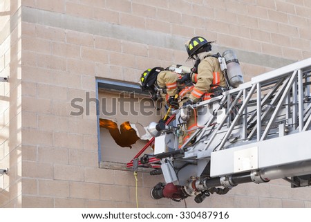 Fire Fighters breaking in window during training exercise.