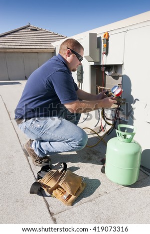 Air Conditioner Repair Man. Using testing equipment on outside roof top unit.
