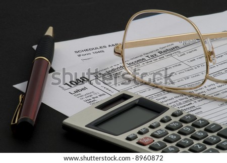 Tax returns, calculator, pen and glasses
