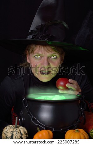friendly witch with red apple and cauldron closer view