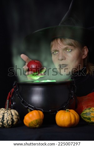 witch with red apple and cauldron with much steam total vertical format