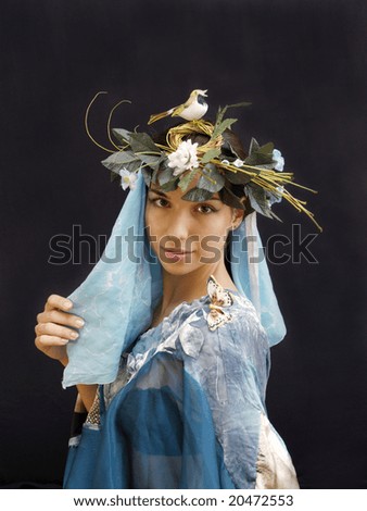 Young lady in fancy spring wreath holding on a black background