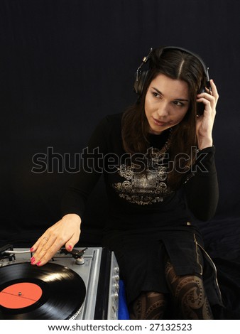 DJ lady in headphones with a vintage record player