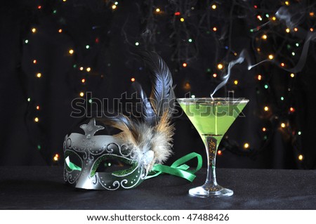 Green fancy mask with smoking candle and blinking lights on black