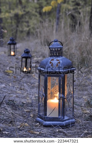 Antique lantern on a forest path in the dark of autumn twilight