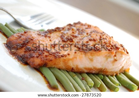 Smoked salmon fillet with honey mustard sauce on a bed of green beans