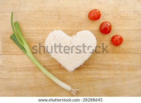 Heart shaped sandwich with spring onions and tomatoes