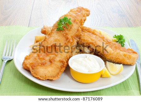 Delicious battered fish on a plate with chips