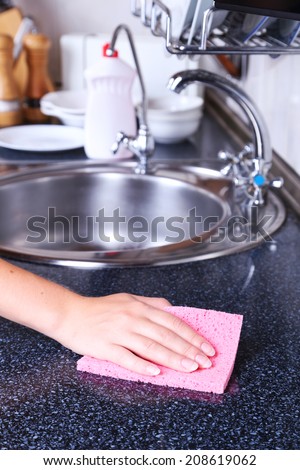 Cleaning kitchen with sponge