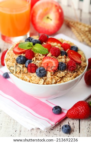 Oatmeal with berries on white wooden background